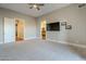 Large bedroom with TV, carpet, and access to bathroom at 24005 N 45Th Dr, Glendale, AZ 85310