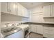 Modern laundry room with white cabinets and granite countertops at 24005 N 45Th Dr, Glendale, AZ 85310