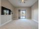 Spacious bedroom with sliding door to patio and wall-mounted TV at 24005 N 45Th Dr, Glendale, AZ 85310
