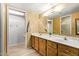 Double vanity bathroom with wood cabinets and a large mirror at 310 N 65Th St # 13, Mesa, AZ 85205