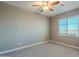 Bedroom with ceiling fan, window and carpet flooring at 36145 N Desert Tea Dr, Queen Creek, AZ 85140