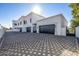 Luxury home with a large, patterned paver driveway and three-car garage at 1480 E Raven Ct, Gilbert, AZ 85297