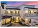 Luxury two-story home with a courtyard and balconies at dusk at 1480 E Raven Ct, Gilbert, AZ 85297
