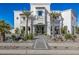 Stunning two-story home with a white stucco exterior, palm trees, and a paved driveway at 1480 E Raven Ct, Gilbert, AZ 85297