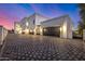 Luxury home with a large, patterned paver driveway and three-car garage at night at 1480 E Raven Ct, Gilbert, AZ 85297