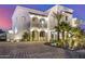 Luxury home at night with beautiful landscaping and a paved driveway at 1480 E Raven Ct, Gilbert, AZ 85297