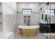 Elegant bathroom with freestanding gold tub, marble tile, and walk-in shower at 1480 E Raven Ct, Gilbert, AZ 85297