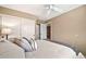 Well-lit bedroom with ceiling fan and sliding door closet at 6782 W Firebird Dr, Glendale, AZ 85308