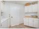 Bright laundry room with washer, dryer, cabinets, and countertop at 10637 W Welk Dr, Sun City, AZ 85373