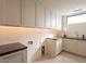Clean laundry room with built-in cabinets and modern finishes at 37200 N Cave Creek Rd # 1002, Scottsdale, AZ 85262
