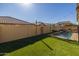 Green grass yard and a view of the pool through the fence at 9645 E Theia Dr, Mesa, AZ 85212