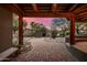 Covered patio with wooden beams, brick flooring, and a view of the gate at 9422 E Diamond Rim Dr, Scottsdale, AZ 85255