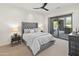 Grey bedroom with plush bed, dark wood headboard, and access to patio at 27225 N 71St Pl, Scottsdale, AZ 85266