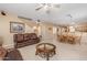 Spacious living room with leather couch, coffee table, and view of dining area at 16170 W Port Royale Ln, Surprise, AZ 85379