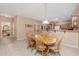 Bright dining room features a wood table with six chairs, view into kitchen at 16170 W Port Royale Ln, Surprise, AZ 85379