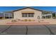 Single-wide manufactured home with covered carport and landscaping at 2400 E Baseline Ave # 201, Apache Junction, AZ 85119