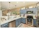 Modern kitchen with stainless steel appliances and blue cabinets at 13349 N 87Th Ln, Peoria, AZ 85381