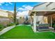 Backyard patio with seating area, artificial turf, and mature plantings at 13349 N 87Th Ln, Peoria, AZ 85381