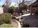 Landscaped backyard with a built-in BBQ, fire pit, and seating area at 4506 E Lone Cactus Dr, Phoenix, AZ 85050