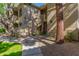 Condo building with walkway, landscaping, and large tree at 9550 E Thunderbird Rd # 155, Scottsdale, AZ 85260