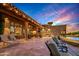 Expansive backyard patio with pool, outdoor kitchen, and seating area at sunset at 9533 E Rising Sun Dr, Scottsdale, AZ 85262