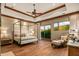 Spacious main bedroom with a four-poster bed, sitting area, and access to a private patio at 9533 E Rising Sun Dr, Scottsdale, AZ 85262