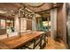 Rustic dining room with a large wooden table and view to the backyard at 9533 E Rising Sun Dr, Scottsdale, AZ 85262