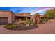 Stone house with an arched entryway and manicured landscaping at 9533 E Rising Sun Dr, Scottsdale, AZ 85262