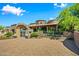 Stone house with arched entryway, courtyard, and landscaped grounds at 9533 E Rising Sun Dr, Scottsdale, AZ 85262