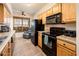Modern kitchen with wood cabinets and black appliances at 14950 W Mountain View Blvd # 1305, Surprise, AZ 85374