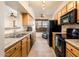 Galley kitchen with wood cabinets and black appliances at 14950 W Mountain View Blvd # 1305, Surprise, AZ 85374