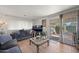 Living room with wood floors, gray sofa, and sliding glass doors to outdoor space at 5201 W Camelback Rd # 204, Phoenix, AZ 85031