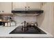 Kitchen detail showing a black electric cooktop and range hood at 5201 W Camelback Rd # 204, Phoenix, AZ 85031