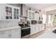 White kitchen with ample cabinetry, gas cooktop, and mosaic backsplash at 959 W Myrtle Dr, Chandler, AZ 85248