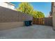 Backyard with concrete patio, trash cans, and wooden gate at 959 W Myrtle Dr, Chandler, AZ 85248