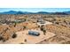 Aerial view showing a manufactured home with surrounding desert landscape and distant mountains at 310 N Brower Rd, Maricopa, AZ 85139