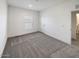 Bright bedroom with gray carpet, window, and neutral walls at 310 N Brower Rd, Maricopa, AZ 85139