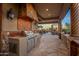 Built-in outdoor kitchen with grill, refrigerator, and stone countertops at 10612 E Winter Sun Dr, Scottsdale, AZ 85262