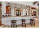 Custom bar with granite countertop, wood cabinetry, and seating at 10612 E Winter Sun Dr, Scottsdale, AZ 85262