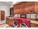 Laundry room with modern appliances and ample wood cabinetry at 10612 E Winter Sun Dr, Scottsdale, AZ 85262