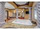 Elegant bathroom with a large jacuzzi tub and decorative columns at 10612 E Winter Sun Dr, Scottsdale, AZ 85262