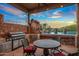 Outdoor kitchen with built-in grill and dining area at 10612 E Winter Sun Dr, Scottsdale, AZ 85262
