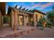 Inviting exterior entrance with a pergola, stone columns, and landscaping at 10612 E Winter Sun Dr, Scottsdale, AZ 85262