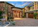 Tuscan-style home with stone facade, fountain, and gated entry at 10612 E Winter Sun Dr, Scottsdale, AZ 85262