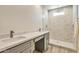 Modern bathroom with double vanity, marble shower, and gray cabinets at 9121 W Debbie Ln, Arizona City, AZ 85123