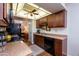 Kitchen with dark wood cabinets, granite counters, black appliances, and a ceiling fan at 19466 N Star Ridge Dr, Sun City West, AZ 85375