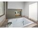 Relaxing bathtub with a built-in fireplace and large window at 10755 E Stoney Ln, Scottsdale, AZ 85262