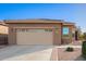 Tan house with a two-car garage and desert landscaping at 2607 E San Simeon Dr, Casa Grande, AZ 85194