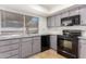 Modern kitchen with gray cabinets, black appliances, and tile flooring at 16053 N 26Th Cir, Phoenix, AZ 85023