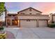 Two-story house with three-car garage, desert landscaping, and warm-toned stucco at 13128 N 104Th Pl, Scottsdale, AZ 85260